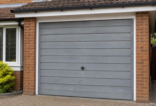 Garage door before repainting, showing a tired and faded exterior finish