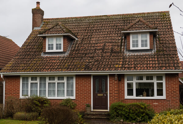 Clay tile roof in Northampton before cleaning, with moss, algae and surface discolouration