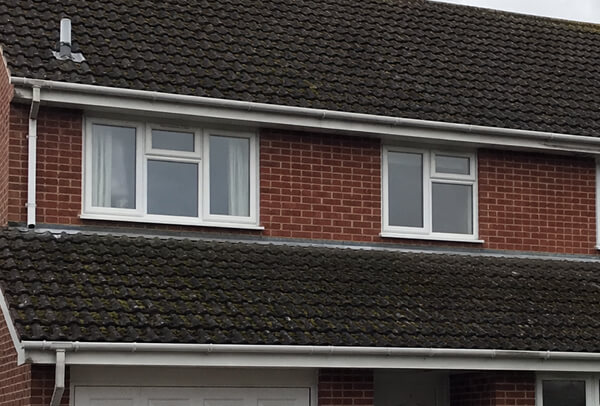 Concrete tile roof in Northampton before cleaning, with moss and dark weather staining