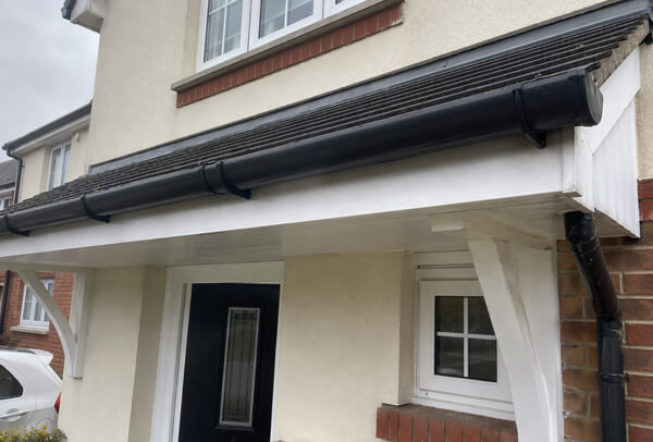 Gutter and downpipe in Northampton after clearing, with rainwater able to flow away