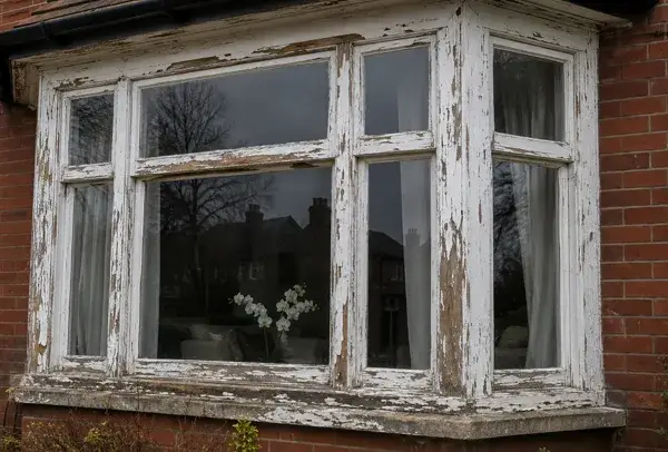 Weathered timber window frames before repainting