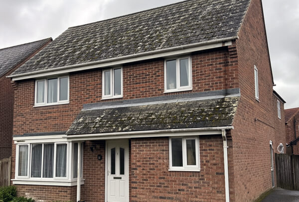 Slate roof in Northampton before cleaning, with moss and weather staining across the roof