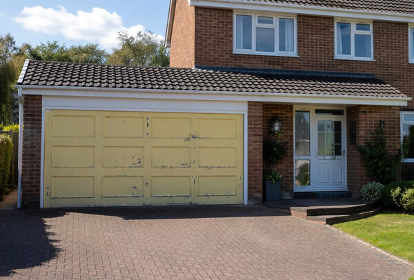 Steel garage door with a faded, worn finish before painting