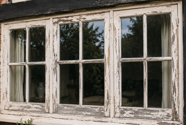 Weathered timber window frames before repainting in Kettering