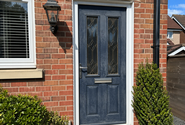 Wooden front door in Northampton before painting, with weathering and a worn finish