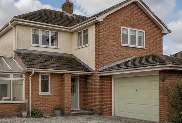 Home in Stevenage before exterior painting with faded frames garage door and roofline details